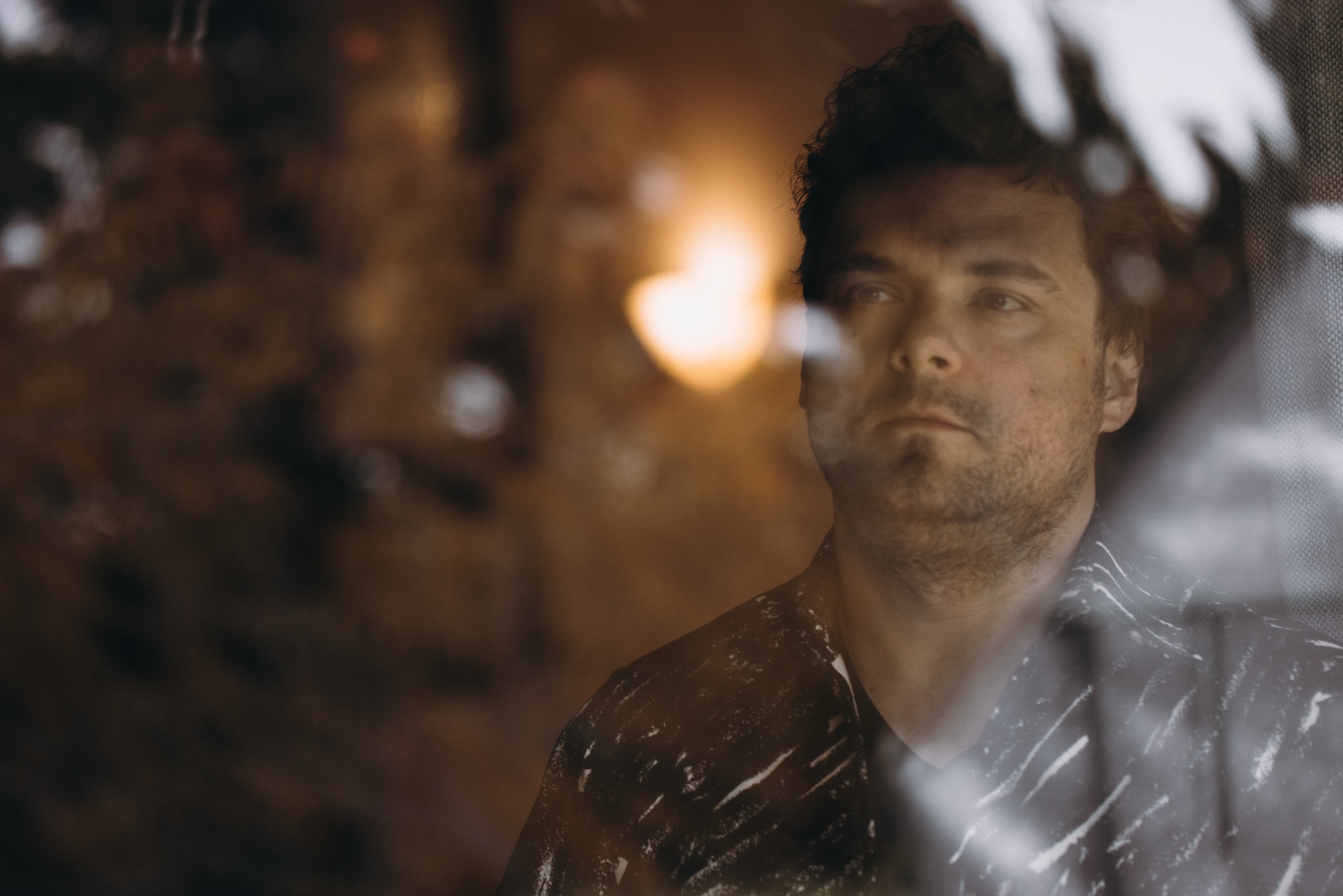 MAQ, seen through rain-streaked glass and city lights